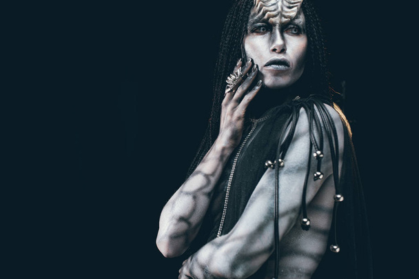 Une jeune femme à l'image d'un extraterrestre humanoïde avec des cornes sur la tête et un motif sur le corps comme un reptile. Espace de copie
. - Photo, image