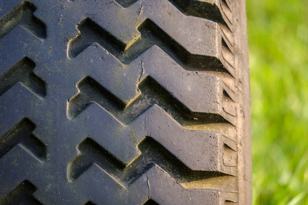 viejo tractor con neumáticos de goma en el patio verde del campo en el tiempo de verano verde
 - Foto, Imagen