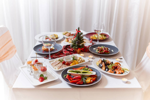 Christmas themed dinner table with a variety of appetizers and salads. - Fotoğraf, Görsel