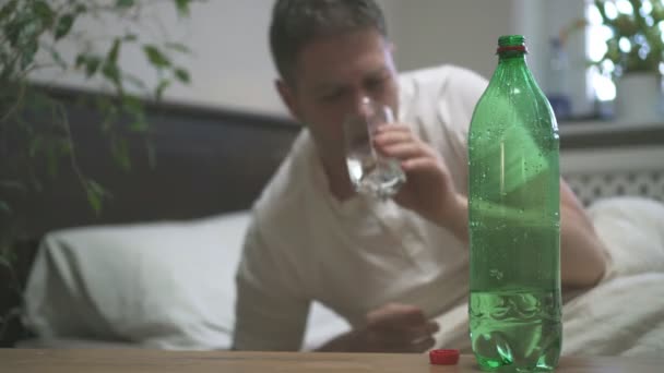Man drinking mineral water and suffering from hangover. - Footage, Video