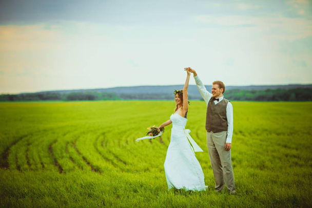 bride and groom stand on the background of the field. - Photo, image