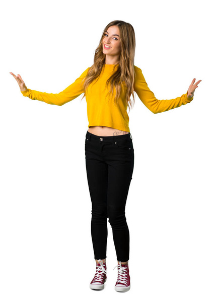 Снимок в полный рост молодой девушки в желтом свитере, гордой и самодовольной в любви, на изолированном белом фоне
 - Фото, изображение