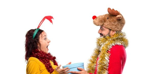 Pari pukeutunut joulun vapaapäiviä varten pitäen lahjaa eristetyllä taustalla
 - Valokuva, kuva