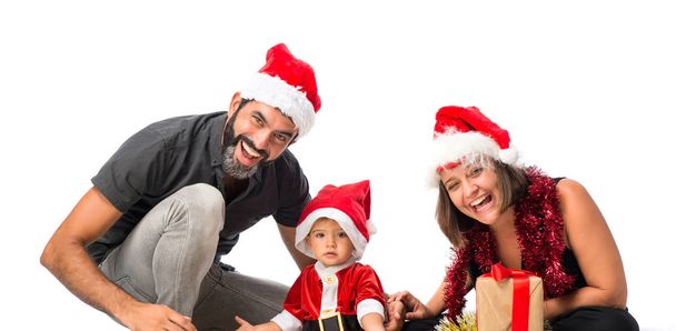 entzückendes kleines Baby mit seinen Eltern auf Weihnachtsfeiern auf isoliertem weißem Hintergrund - Foto, Bild