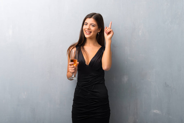 Teenager girl with champagne celebrating new year 2019 counting number one sign - Photo, Image