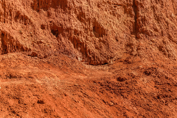 Abstract natural background from texture of the mountain slope with red soil, clay and stones - Фото, изображение