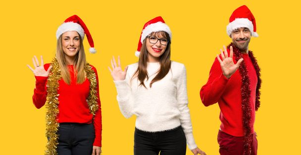 Група людей білявка одягнені для різдвяних свят Рахункова п'ять пальцями на жовтому фоні - Фото, зображення