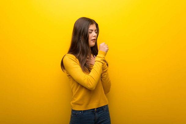Ragazza adolescente su sfondo giallo vibrante sta soffrendo di tosse e sentirsi male
 - Foto, immagini