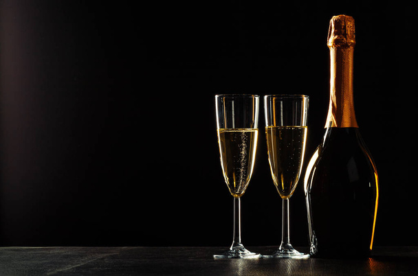bottle of champagne and glasses over dark background - Photo, Image