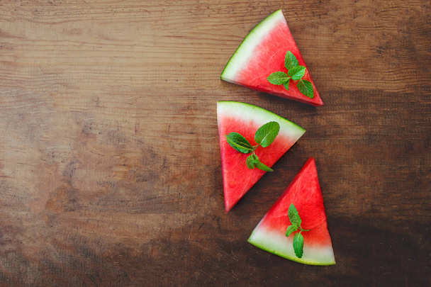 Watermelon slice with mint on rustic wood background. Copyspace.. Flat lay. Summertime concept - Foto, immagini
