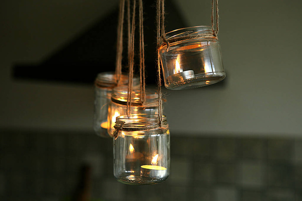 Aromatische kaarsen in glazen potten opknoping in de keuken. DIY kaarsen in glazen potten opknoping op linnen jute.  - Foto, afbeelding