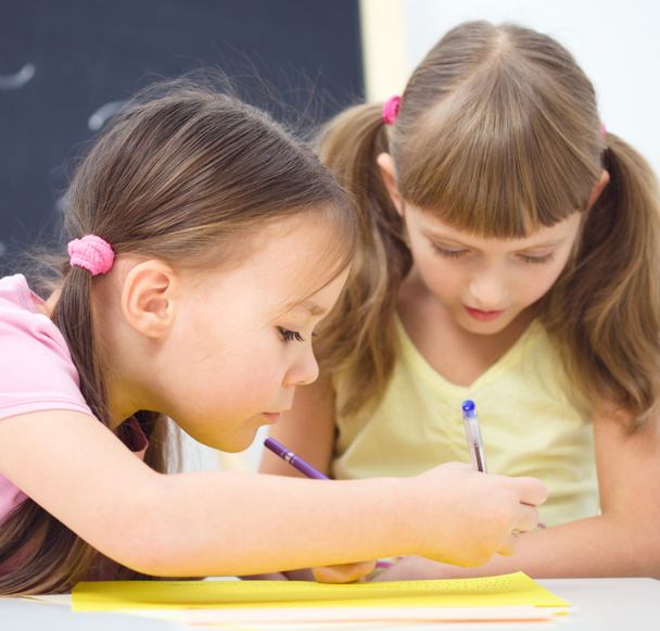 Маленькі дівчата пишуть ручкою
 - Фото, зображення