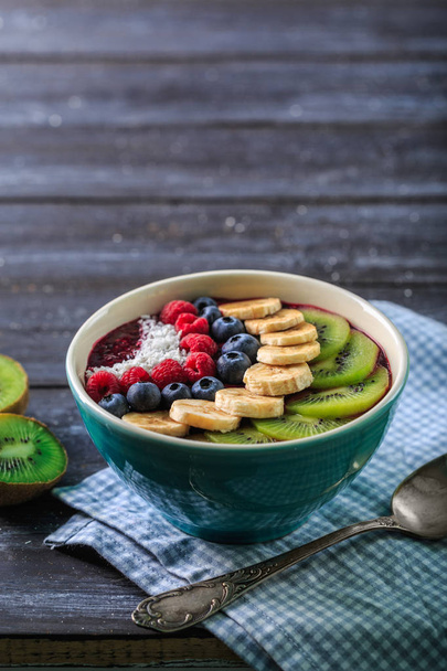 Healthy breakfast with delicious acai smoothie in bowl on dark background - Fotoğraf, Görsel