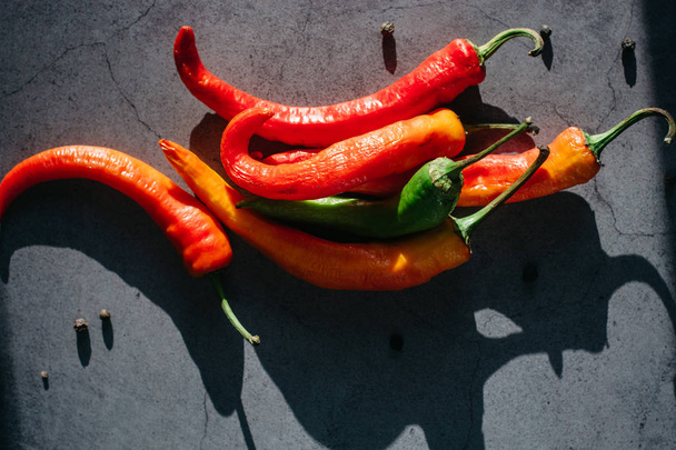  Pods of red and green hot chili peppers on a gray background. Place for text - Φωτογραφία, εικόνα