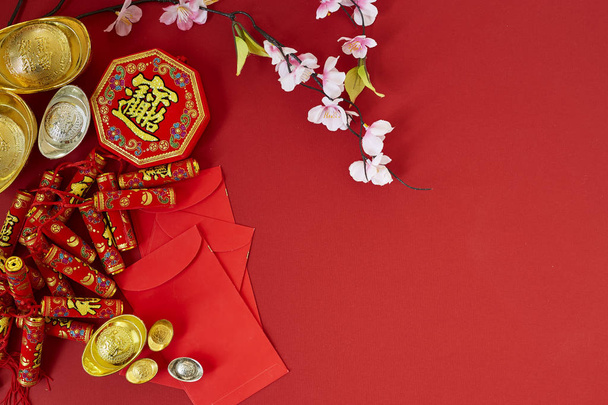 Chinese new year 2019 festival decorations.firecrackers,gold ingot,red packet,plum blossom,on red background. Top view accessories. Translation: Fu meaning good fortune, Chun meaning spring. - Zdjęcie, obraz
