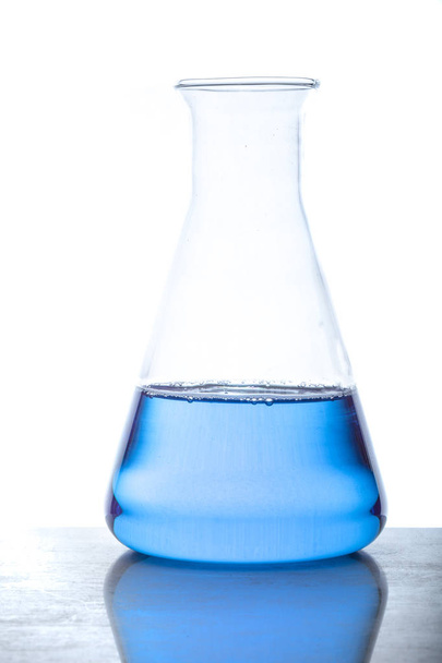 Un frasco de vidrio con líquido azul utilizado en experimentos químicos
 - Foto, Imagen