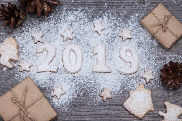 Numeri 2019 da biscotti o biscotti con regali, abete, pino sullo sfondo rustico in legno. Anno nuovo 2019. Vista dall'alto. Piatto. Composizione natalizia
. - Foto, immagini