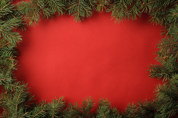 Christmas and New Year frame for text with a Christmas tree on a red bright background. view from above. - Photo, Image