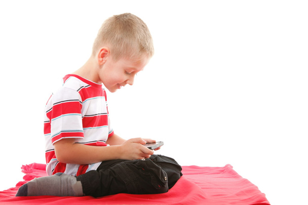 Child plays games on the mobile phone - Φωτογραφία, εικόνα