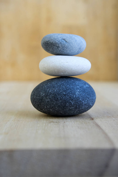 Group of zen stones on wooden mat, pebbles, light grey, dark grey, white, massage pebbles - Foto, immagini
