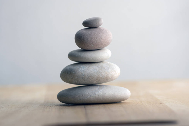 Stone cairn on striped grey white background, five stones tower, simple poise stones, simplicity harmony and balance, rock zen sculptures - Photo, Image