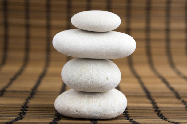Stone cairn on brown wooden background, group of stones tower, simple poise stones, simplicity harmony and balance, rock zen sculptures - Fotografie, Obrázek
