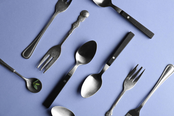 Cucharas y tenedores sobre fondo de color
 - Foto, Imagen