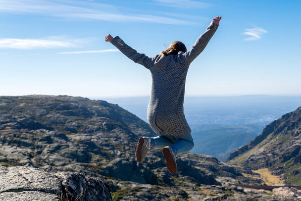 Девушка прыгает в горы. Прыжки на горную скалу. Расслабляться, чувствовать себя живым, дышать свежим воздухом, получить свободу от работы
 - Фото, изображение