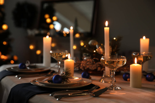 Зажигание свечей на красивом столе на рождественский ужин
 - Фото, изображение