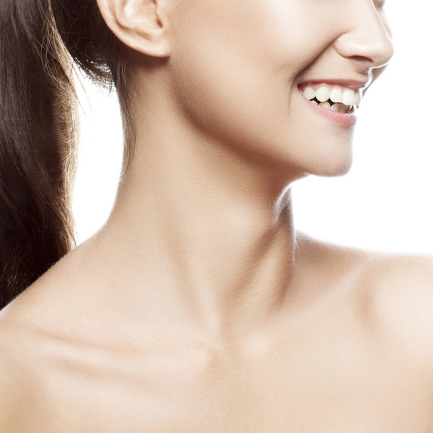 Vista parcial del retrato de mujer sonriente sobre fondo blanco
 - Foto, Imagen