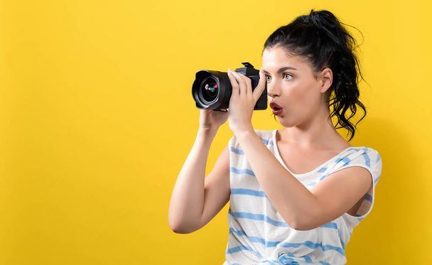Young woman with a professional camera - Foto, afbeelding