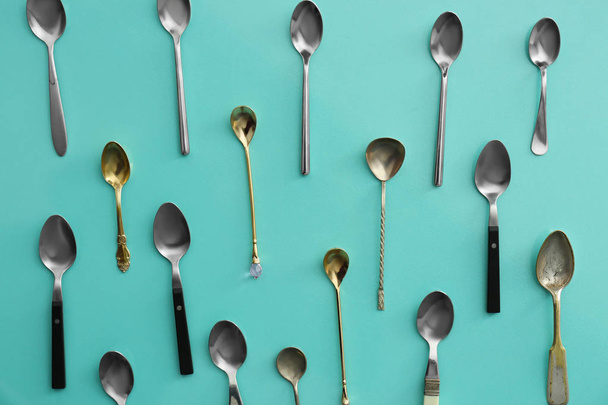 Many spoons on color  background, flat lay - Φωτογραφία, εικόνα