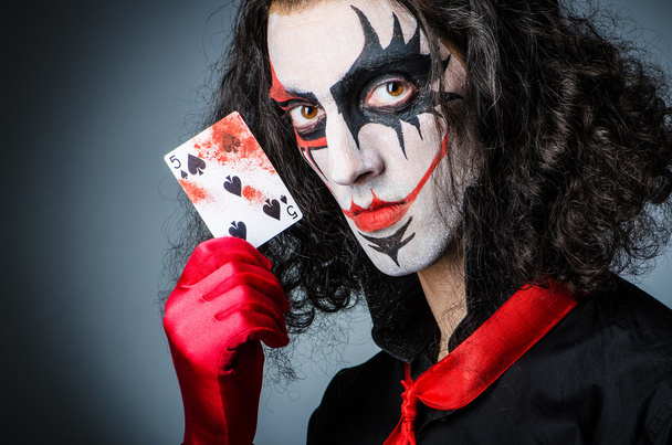 Evil clown with cards in dark room - Photo, Image