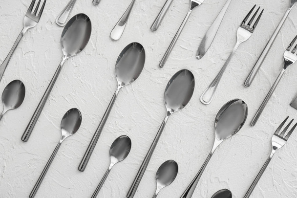Spoons and forks on white textured  background, flat lay - 写真・画像