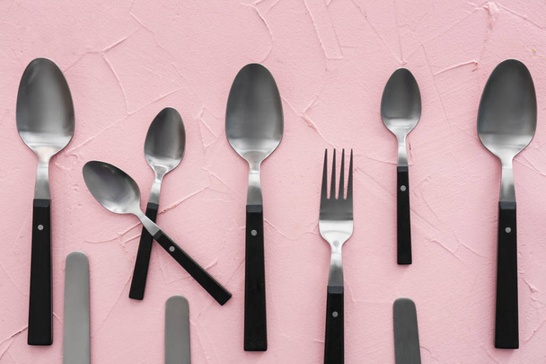 Cucharas y tenedor sobre fondo de color, disposición plana
 - Foto, Imagen