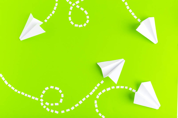 Paper airplanes  connected with dotted lines on green background. Business concept - Foto, afbeelding