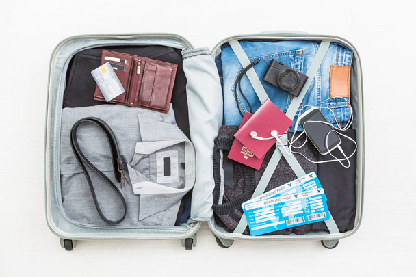 travel traveler traveling bag top open view packing card camera packed credit wallet clothing table leaving departure concept - stock image - Foto, Bild