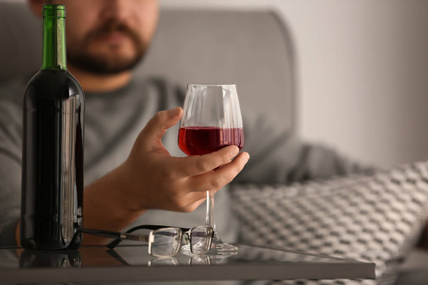 Man with glass of wine relaxing at home - Photo, image