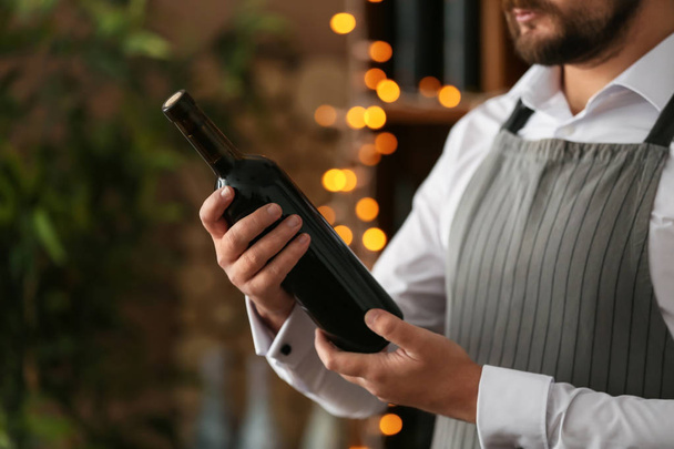 Barman with bottle of wine, closeup - Photo, Image
