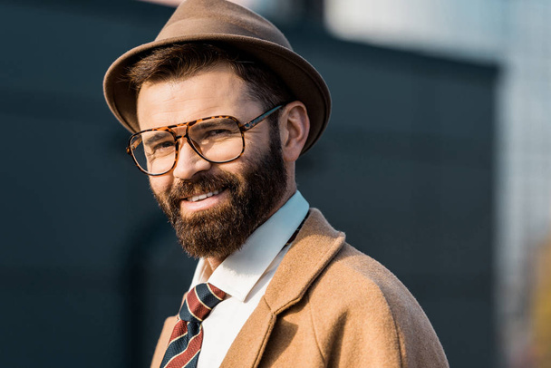 close up of adult smiling businessman in glasses and hat looking at camera - Fotoğraf, Görsel