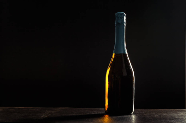 Bottle of champagne on black background. - Фото, зображення