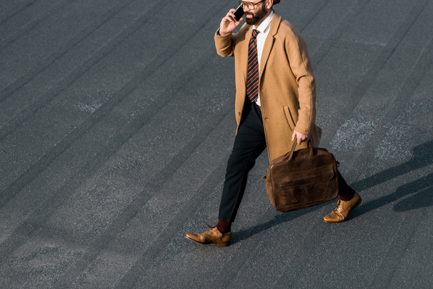 cropped view of bearded businessman in glasses talking on smartphone - Foto, imagen