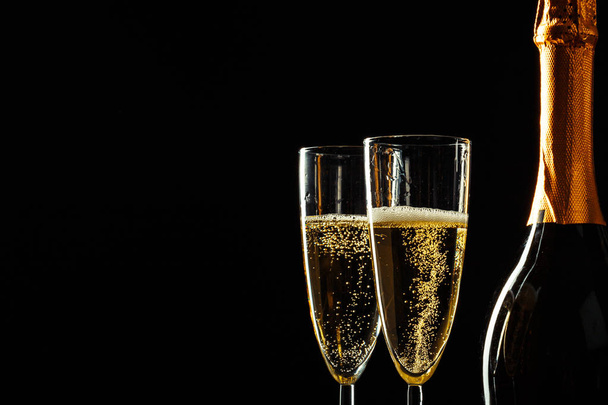 bottle of champagne and glasses over dark background - Photo, Image