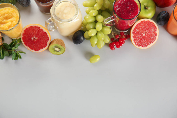 Посуда из вкусных красочных коктейлей с ингредиентами на светлом столе
 - Фото, изображение