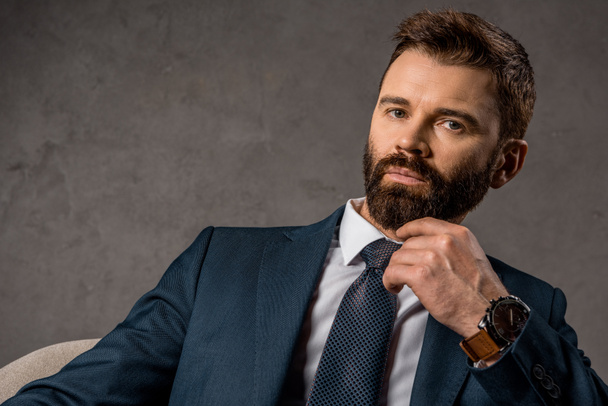 close up of thoughtful businessman in formalwear with watch on hand  - Photo, Image