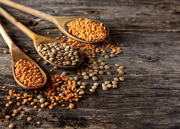 Lentils in spoon on wooden  background. Balanced diet, cooking, vegetarian, raw and clean eating concept. Healthy food. - Photo, Image