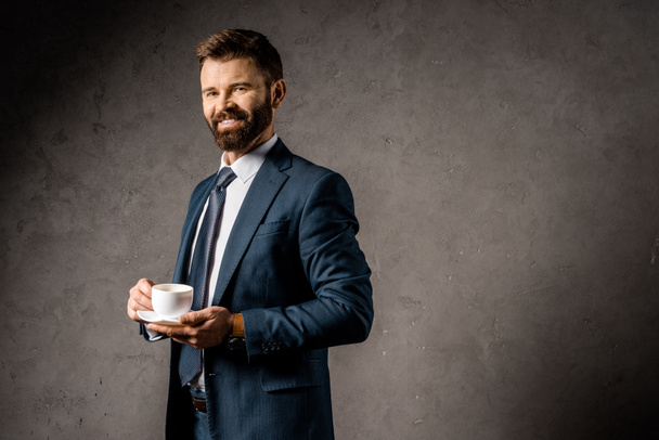 smiling businessman standing with cup of coffee  - Foto, Imagem