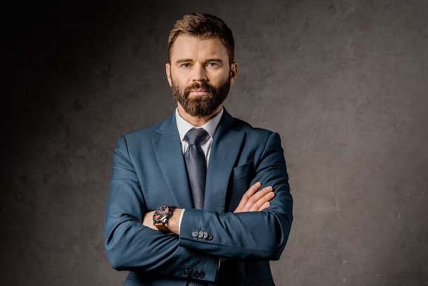 handsome bearded businessman standing with crossed arms  - Foto, imagen