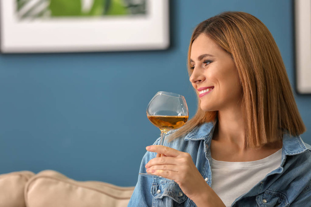 Belle femme avec un verre de vin savoureux à la maison
 - Photo, image
