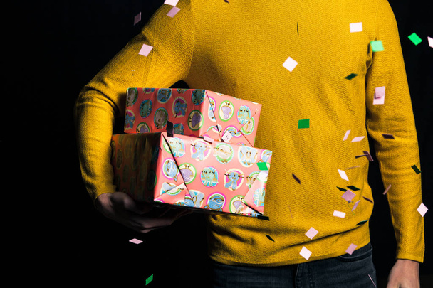 Sarı kazaklı genç adam tutun hediye - Fotoğraf, Görsel